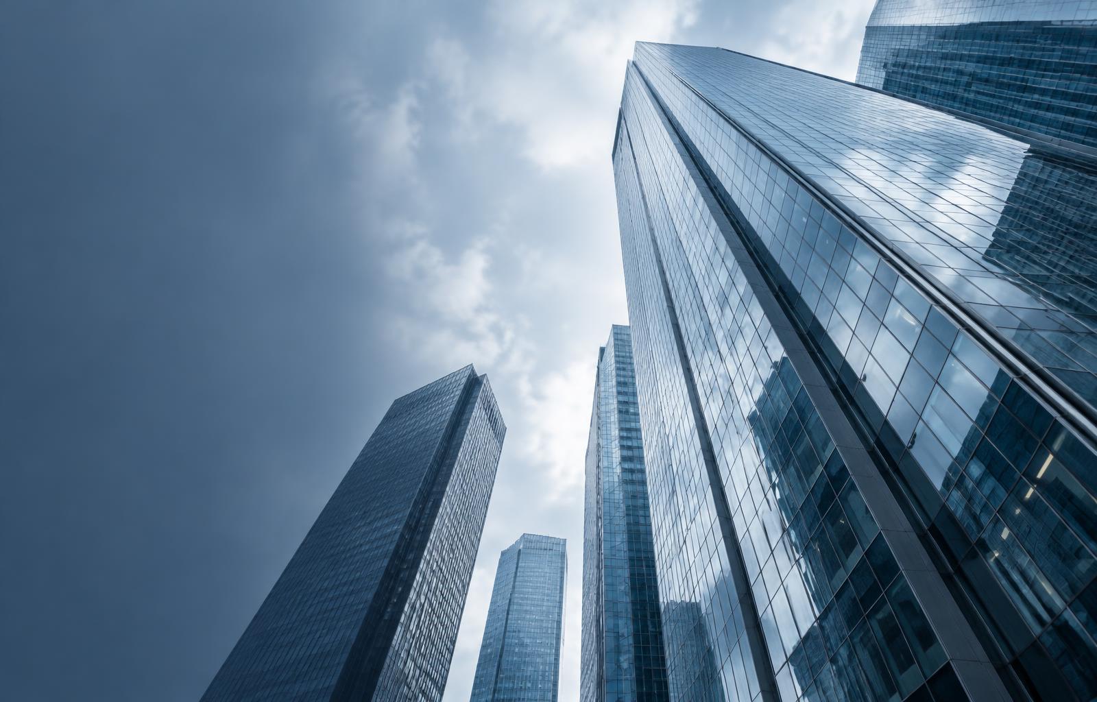 Glass and steel towers viewed against a pale blue sky